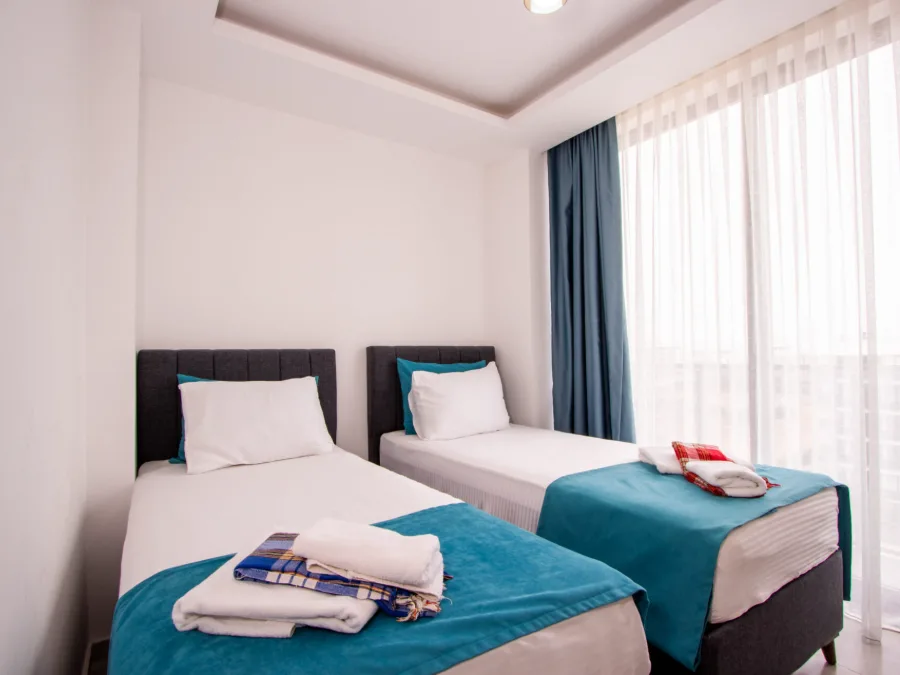Sunset Apartment iki tek kişilik yataklı yatak odası